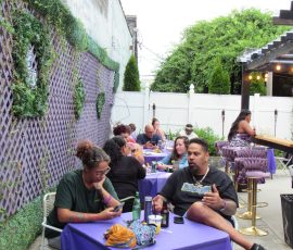 Night fell, but the purple glow kept shining — cheers to 40 years! Group of people enjoying an evening Prince-themed celebration with food and drinks
